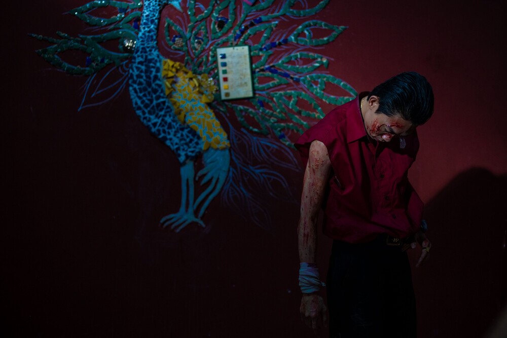 Nhơn gắn liền nhiều màu đỏ, của những chiếc áo, của máu, của bức tường như thành trì bảo bọc anh